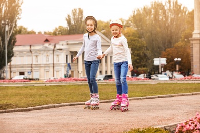 Happy children roller skating on city street