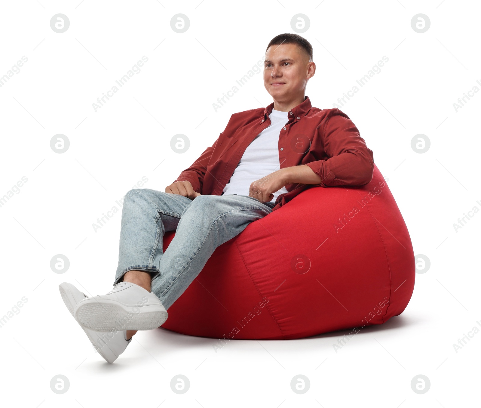 Photo of Handsome man sitting on red bean bag chair against white background