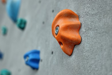 Photo of Climbing wall with holds in gym, closeup