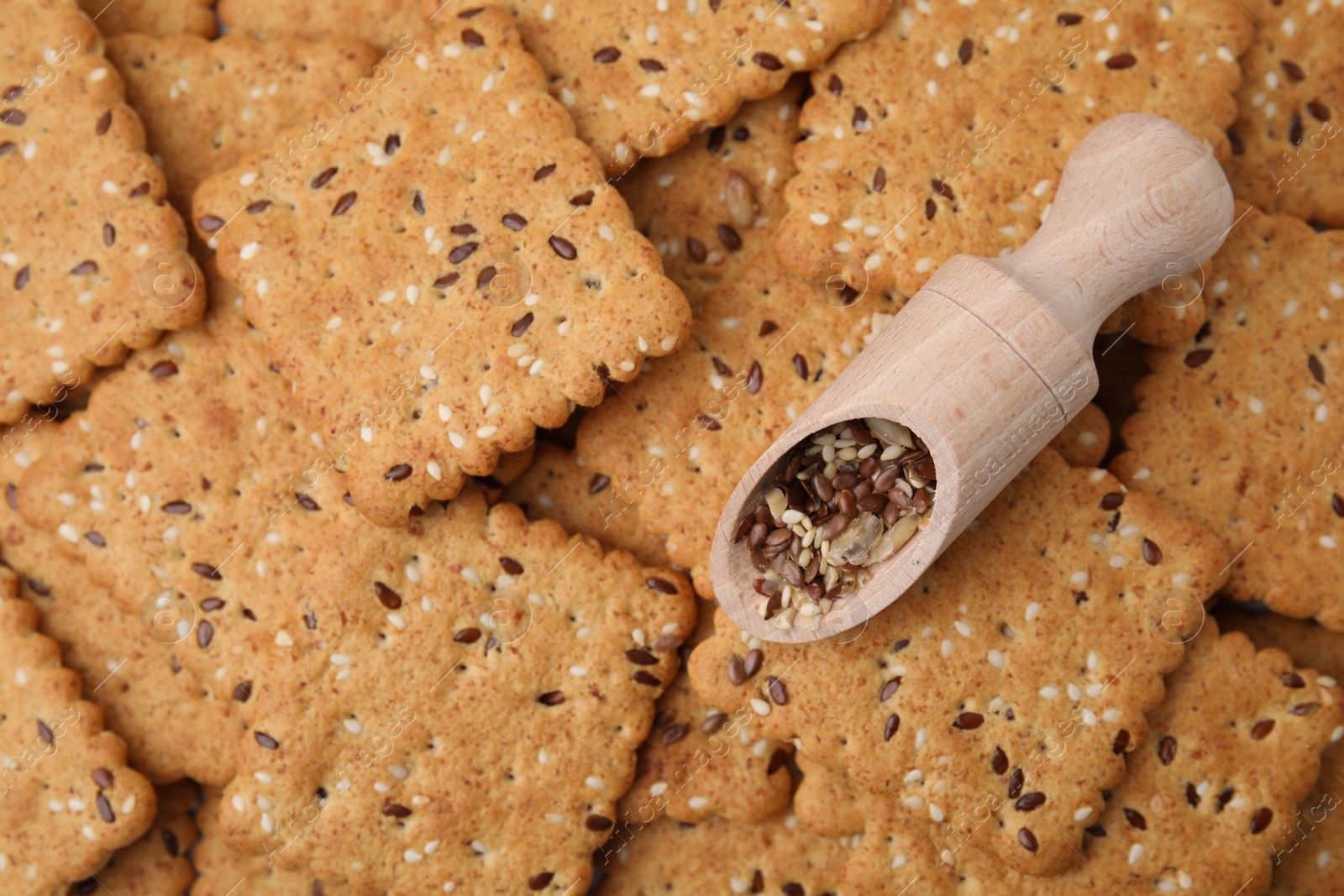Photo of Scoop with grains on cereal crackers with flax and sesame seeds, top view