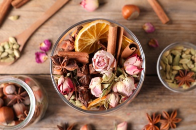 Aroma potpourri with different spices on wooden table, flat lay