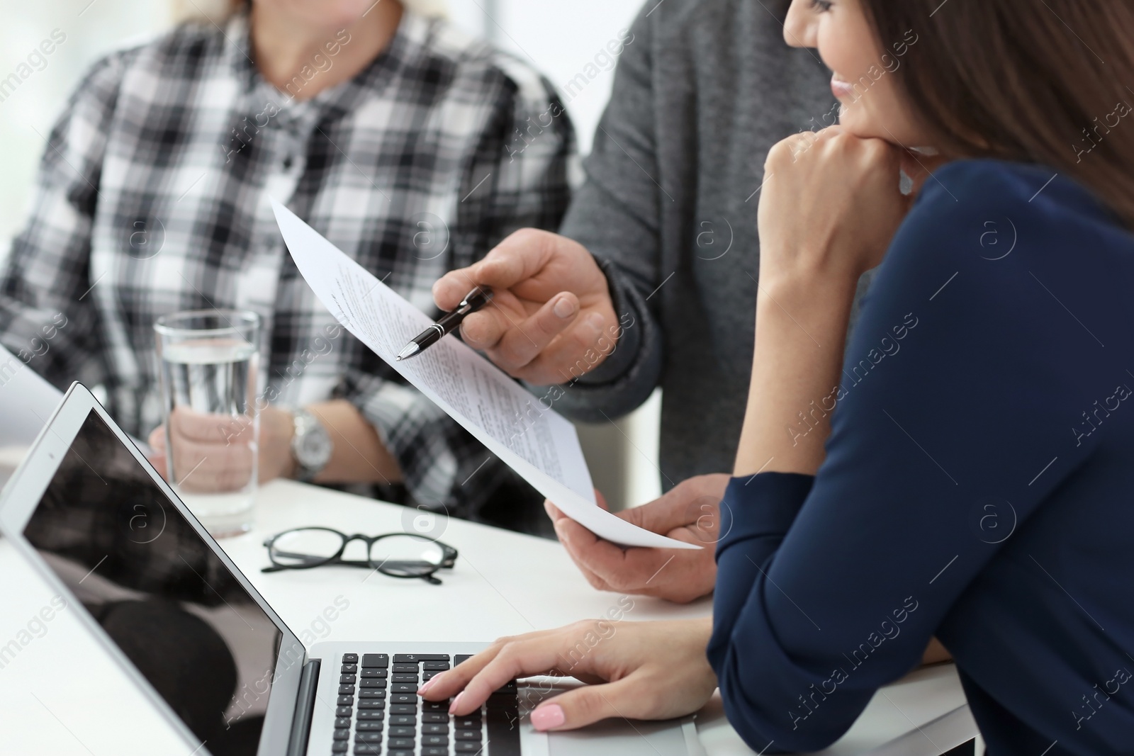 Photo of Mature couple discussing pension with consultant in office