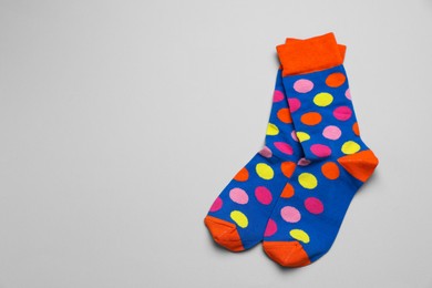 Photo of Colorful socks on light grey background, flat lay. Space for text