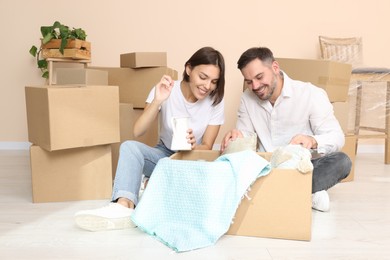 Photo of Happy couple unpacking box in new apartment. Moving day