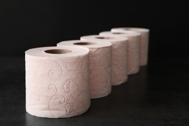 Row of toilet paper rolls on black background