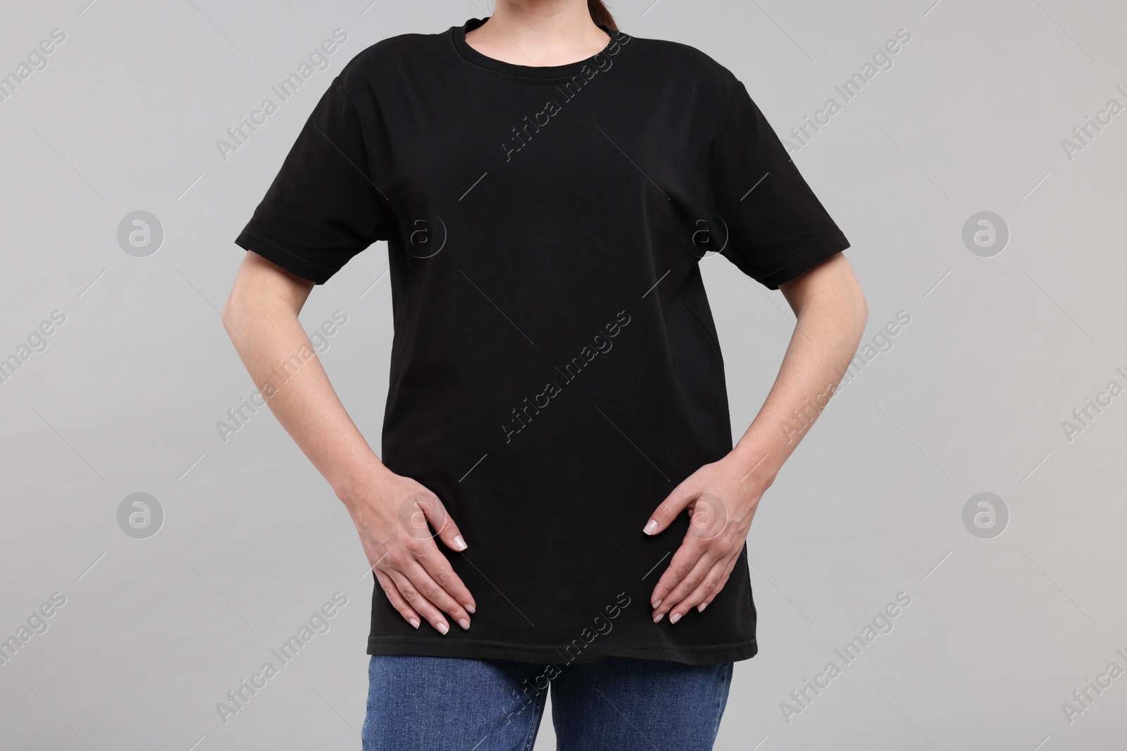 Photo of Woman in stylish black t-shirt light grey on background, closeup