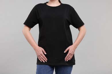 Woman in stylish black t-shirt light grey on background, closeup
