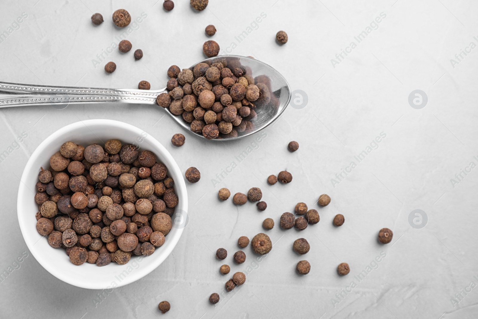 Photo of Black peppercorns on light table, flat lay