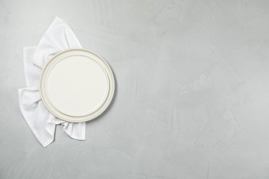 Photo of Elegant plate and napkin on grey table, top view. Space for text