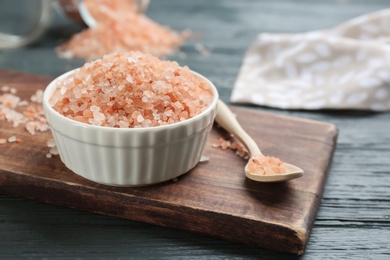 Photo of Pink himalayan salt in bowl and spoon on wooden board