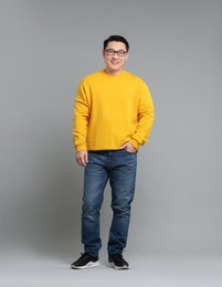 Full length portrait of happy man on grey background