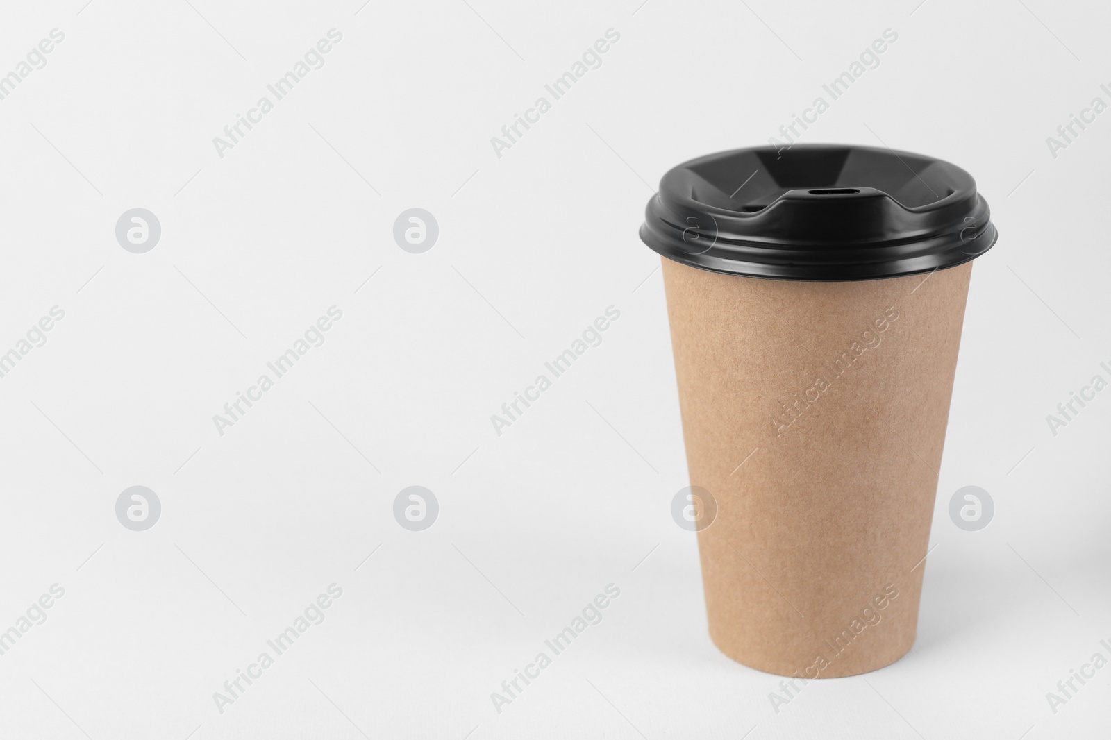 Photo of Paper cup with plastic lid on light background, space for text. Coffee to go