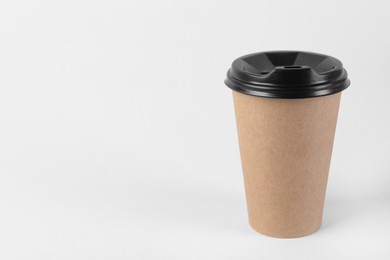 Paper cup with plastic lid on light background, space for text. Coffee to go