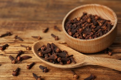 Photo of Aromatic dry cloves on wooden table, closeup