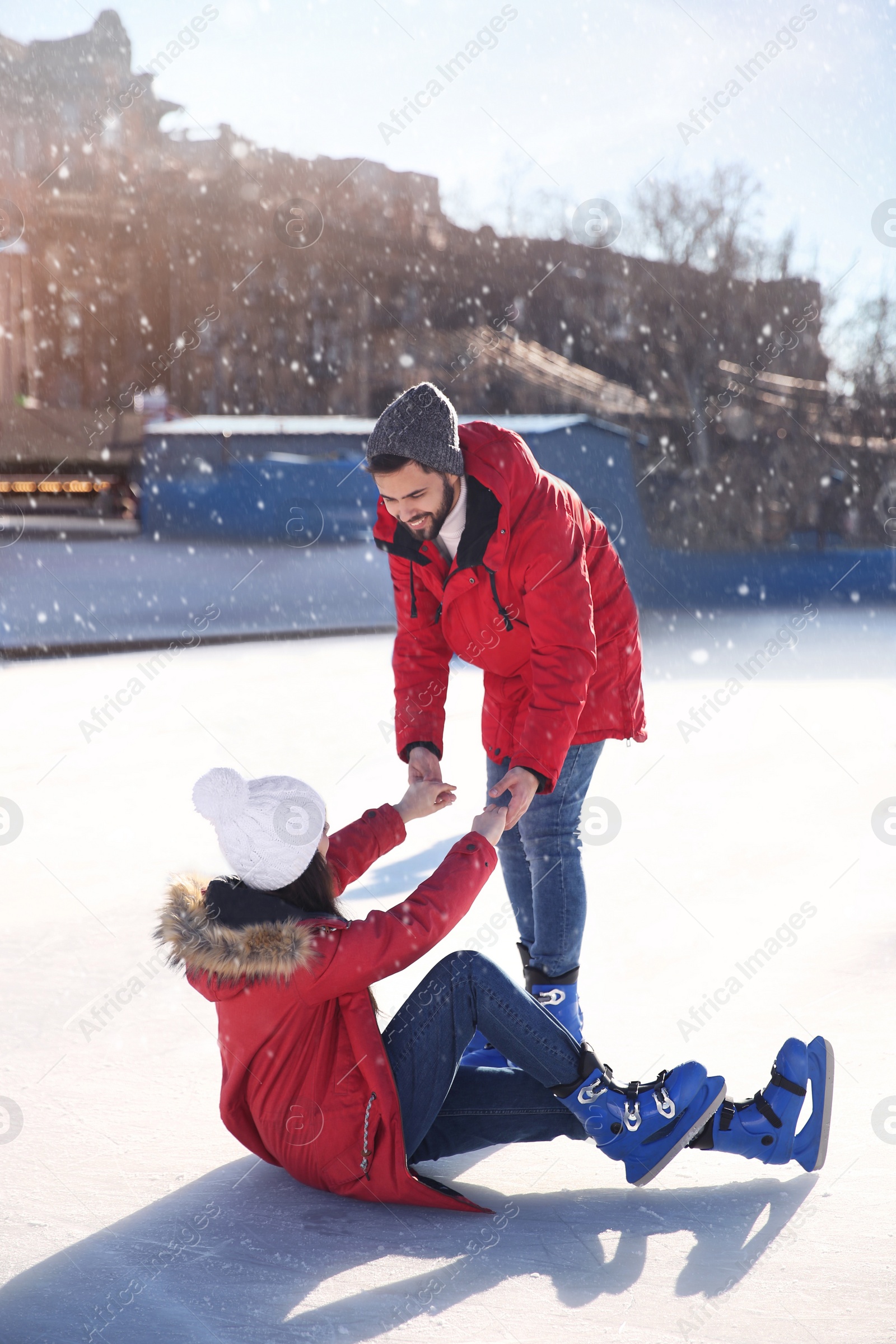 Image of Lovely couple spending time together at outdoor ice skating rink