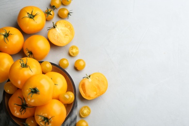 Photo of Ripe yellow tomatoes on grey table, flat lay. Space for text