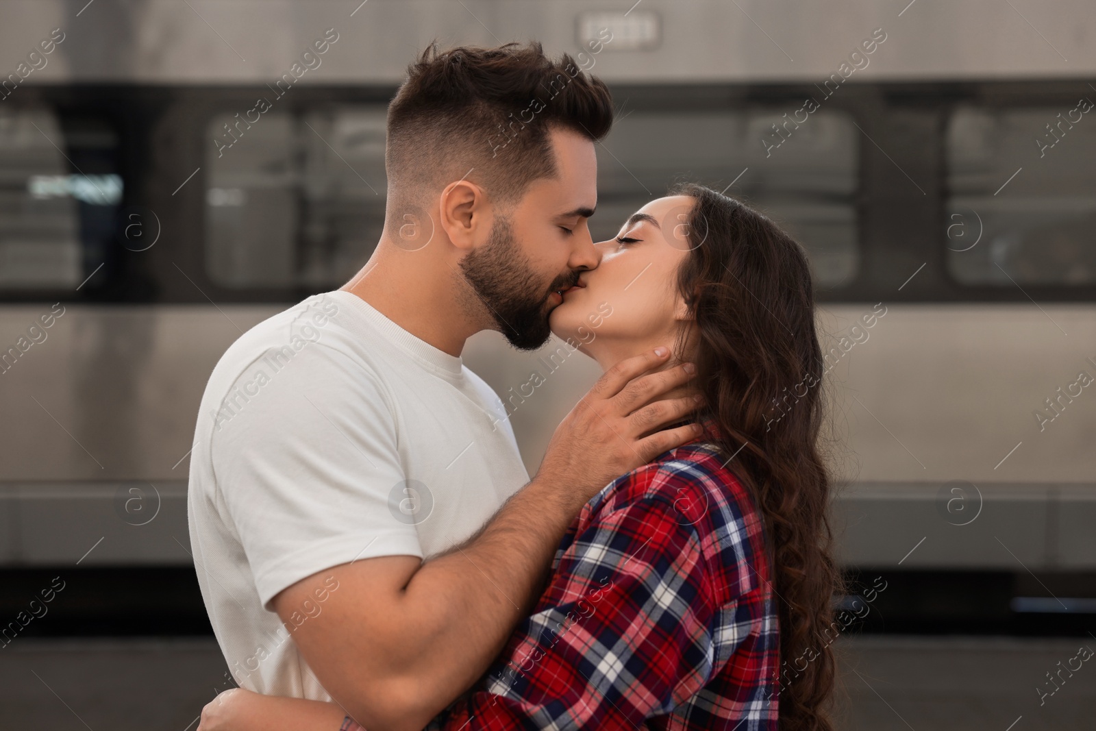 Photo of Long-distance relationship. Beautiful couple kissing on platform of railway station