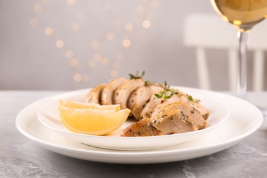 Tasty lemon chicken on light grey marble table, closeup