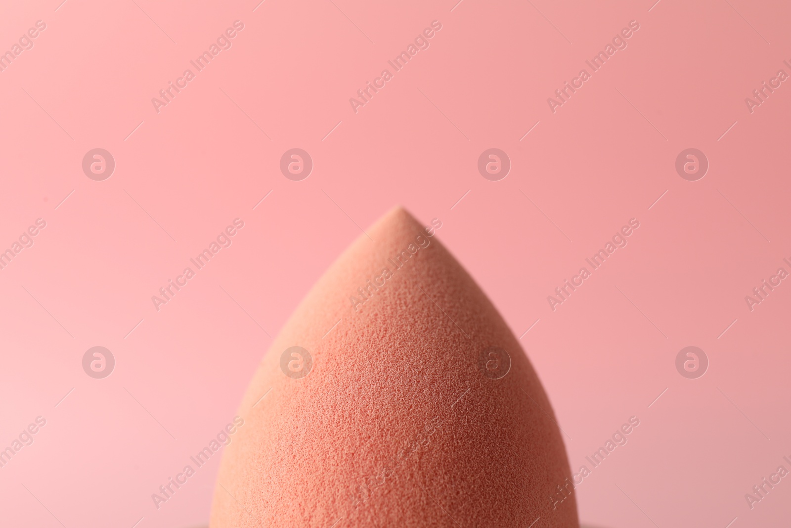 Photo of One makeup sponge on pink background, closeup