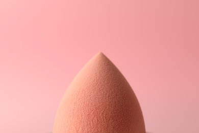 One makeup sponge on pink background, closeup