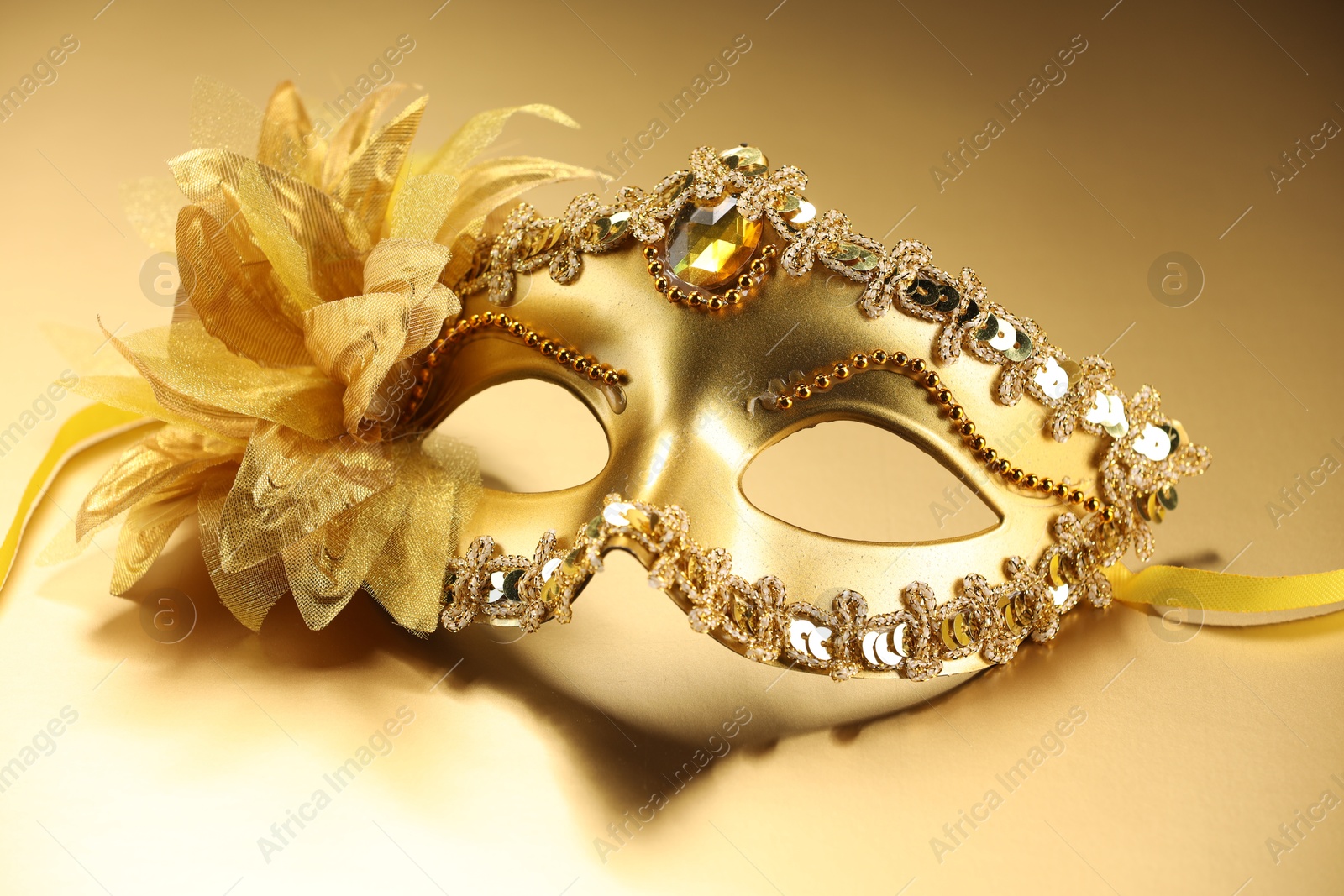 Photo of Beautifully decorated face mask on beige background. Theatrical performance