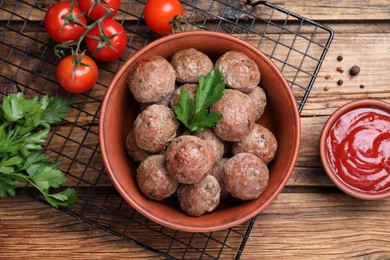 Photo of Tasty cooked meatballs with parsley on wooden table, flat lay