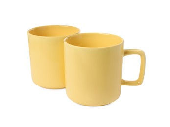 Two yellow ceramic mugs isolated on white