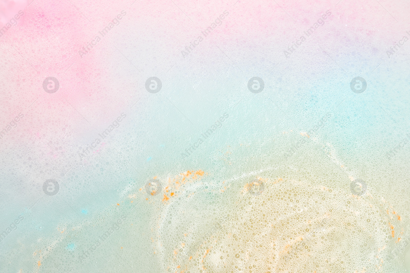 Photo of Colorful foam after dissolving bath bomb in water, closeup