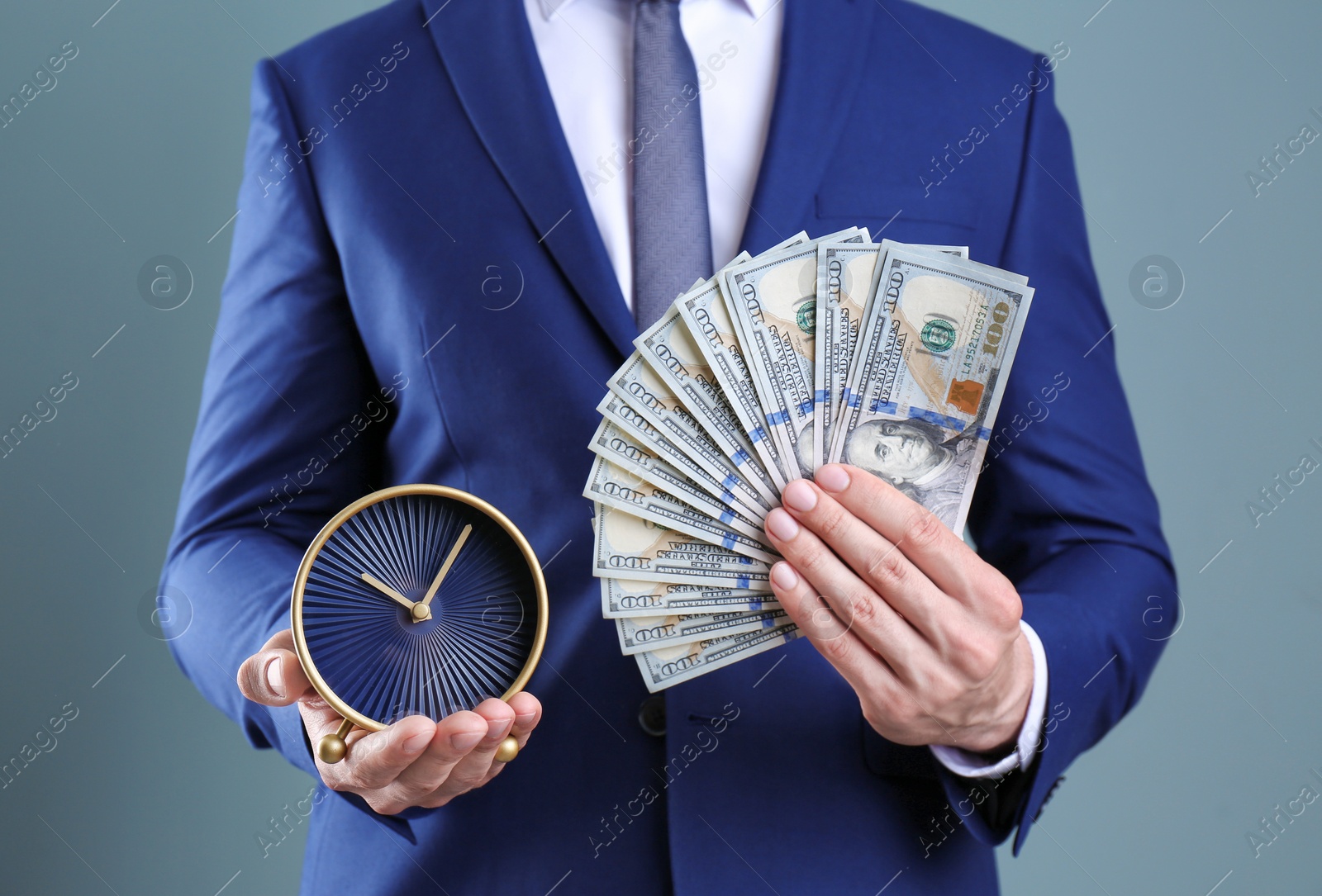 Photo of Young businessman holding clock and money on color background. Time management