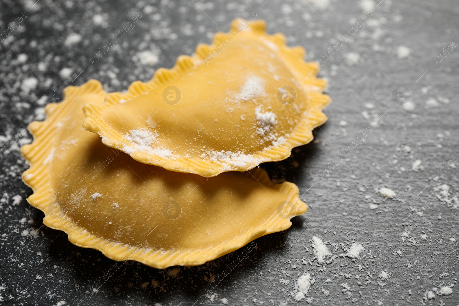 Photo of Ravioli on grey wooden table, closeup. Italian pasta