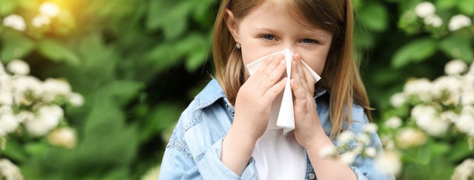 Image of Little girl suffering from seasonal spring allergy outdoors. Banner design