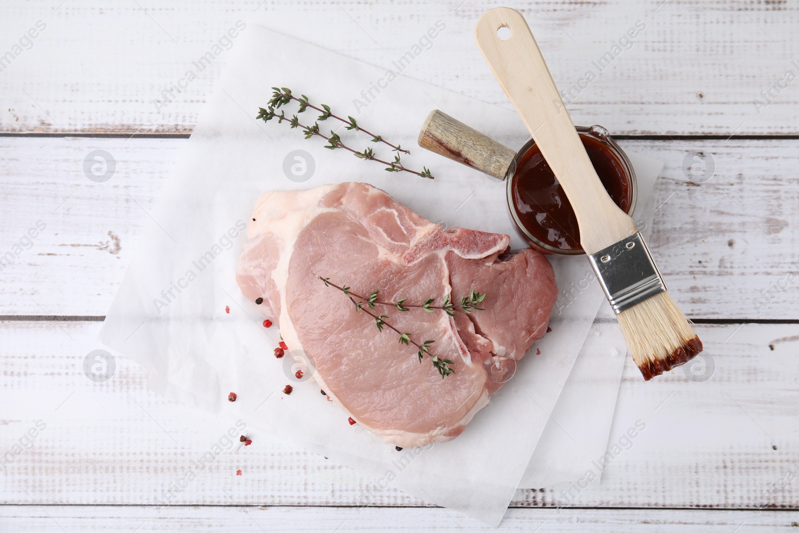 Photo of Raw meat, thyme and marinade on rustic wooden table, flat lay