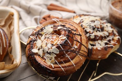 Photo of Delicious rolls with toppings and almond on table, closeup. Sweet buns