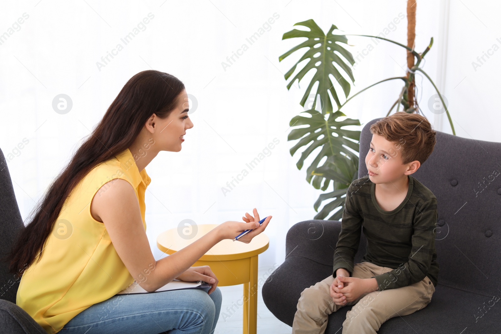 Photo of Child psychologist working with boy in office