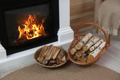 Firewood in wicker baskets near fireplace indoors