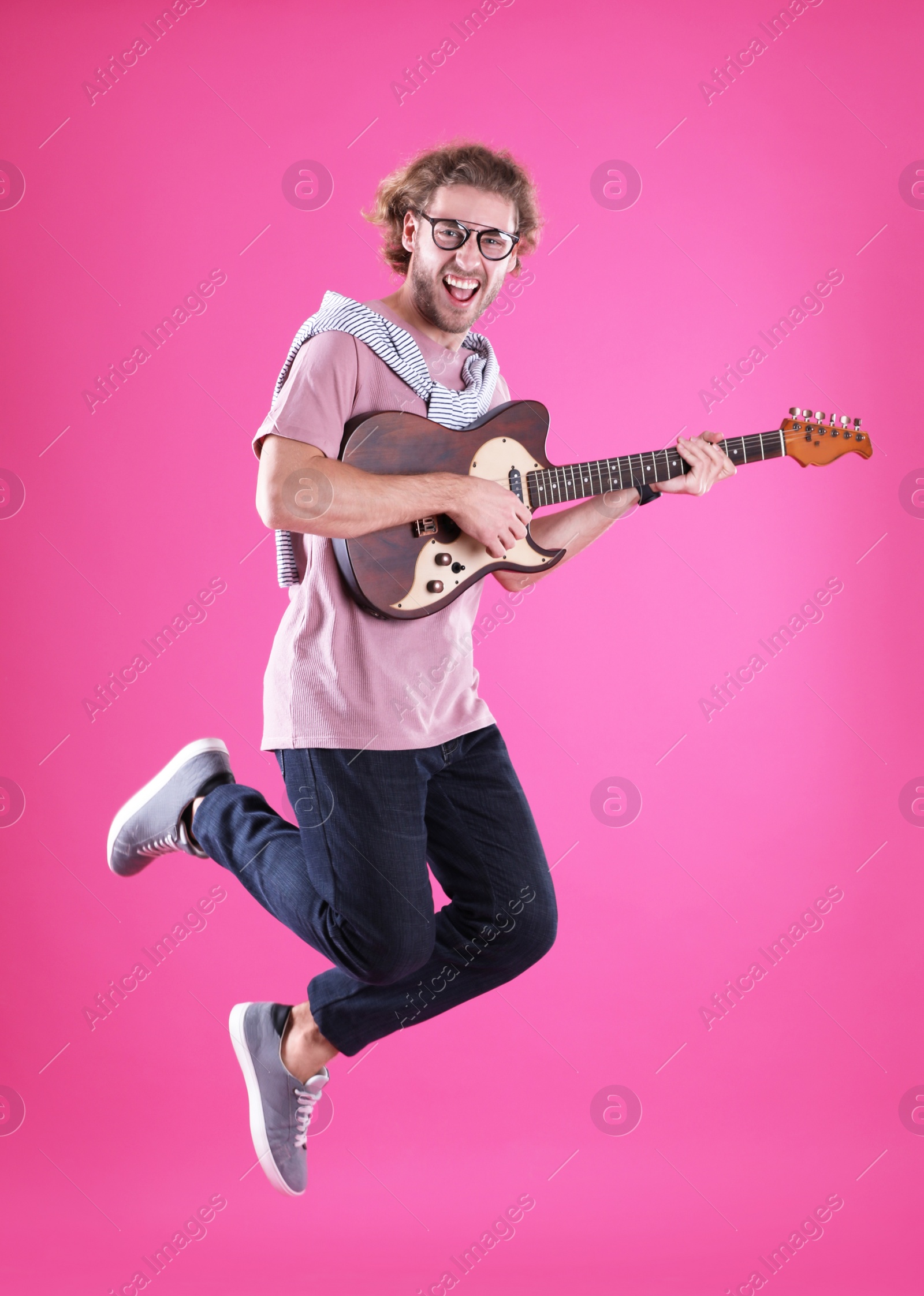 Photo of Young man playing electric guitar on color background