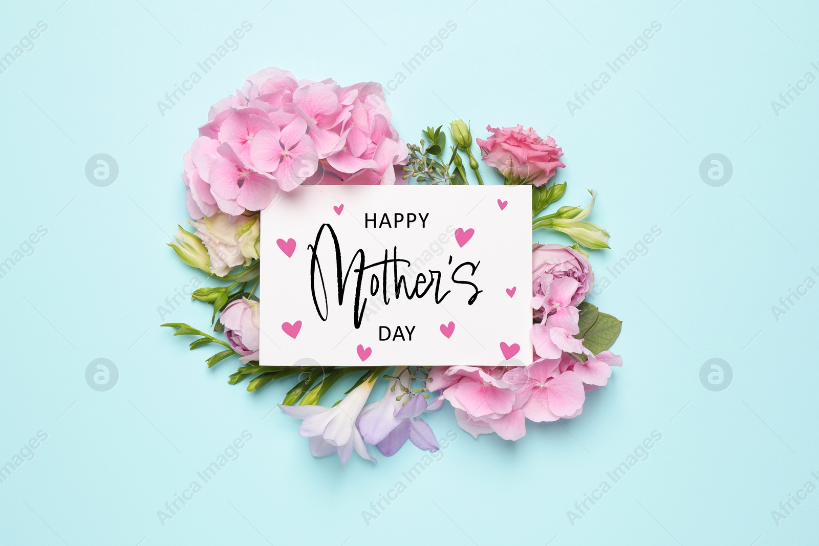 Image of Happy Mother's Day greeting card and beautiful flowers on pale light blue background, flat lay