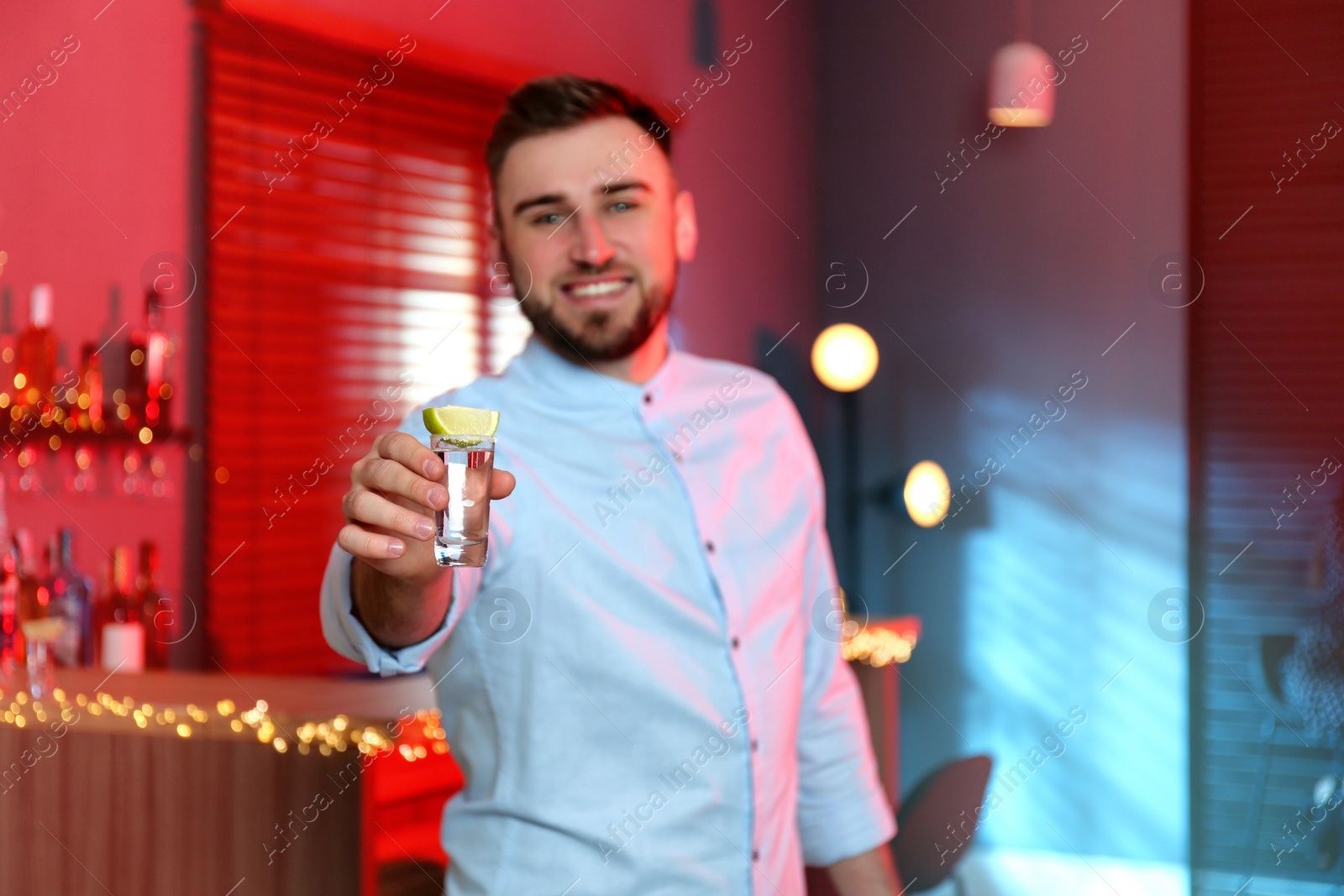 Photo of Young man with Mexican Tequila shot in bar