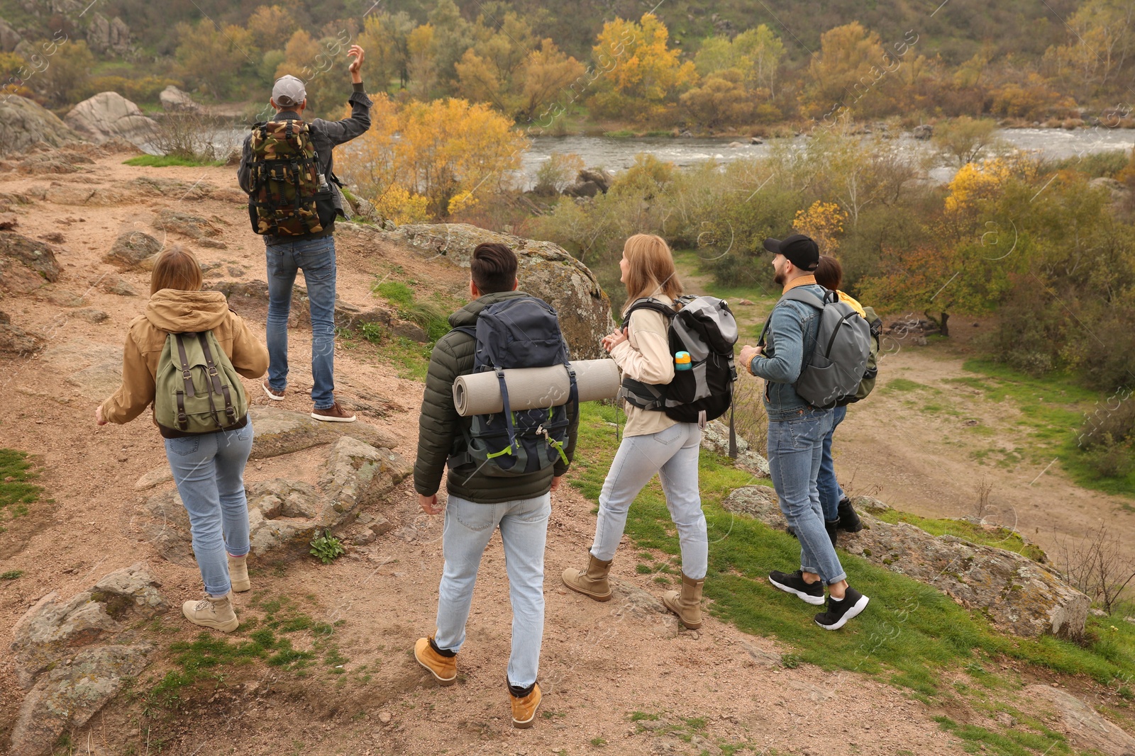 Photo of Group of hikers with backpacks climbing up mountains