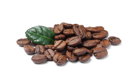 Pile of roasted coffee beans with fresh leaf on white background