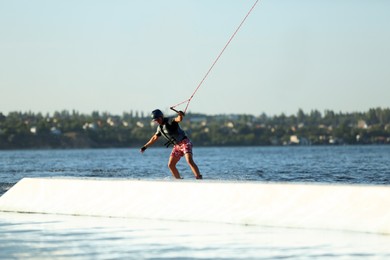 Teenage boy wakeboarding on river. Extreme water sport