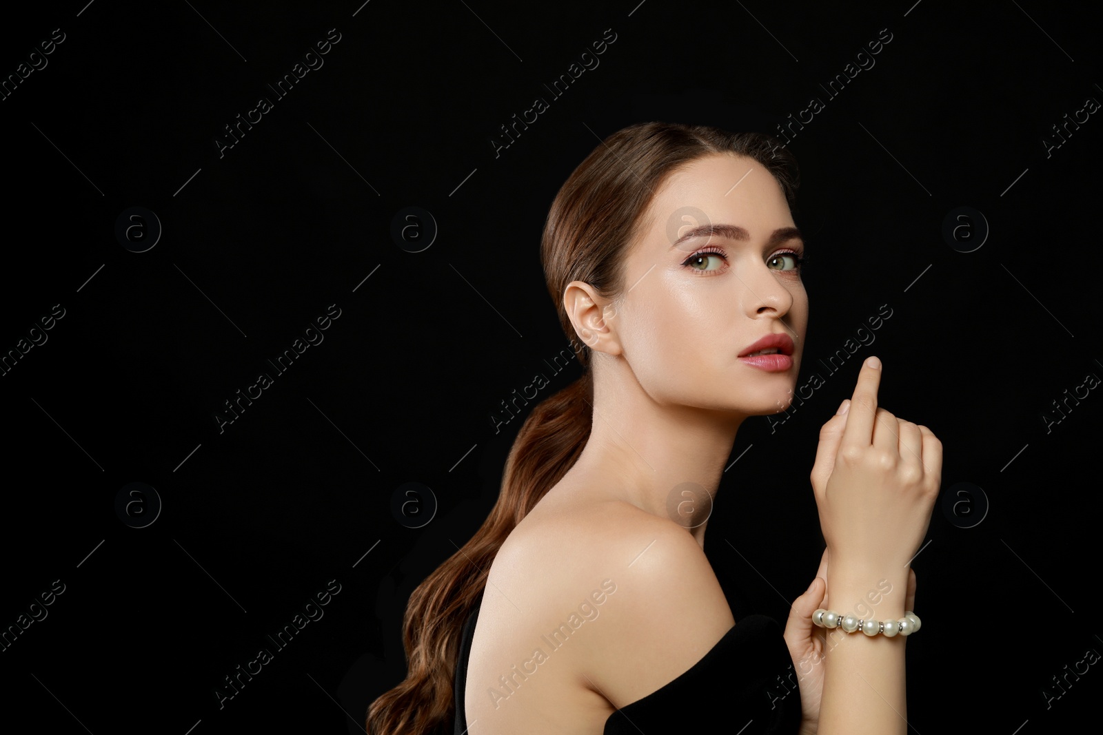 Photo of Young woman wearing elegant pearl bracelet on black background, space for text
