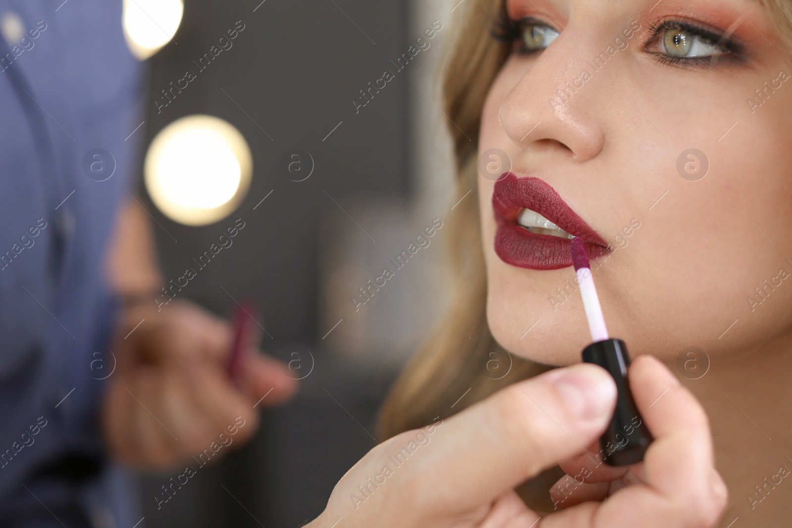 Photo of Professional makeup artist working with client in dressing room, closeup