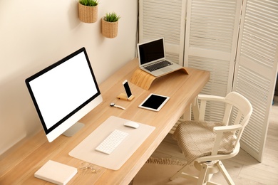 Stylish workplace interior with modern computer on table. Mockup for design