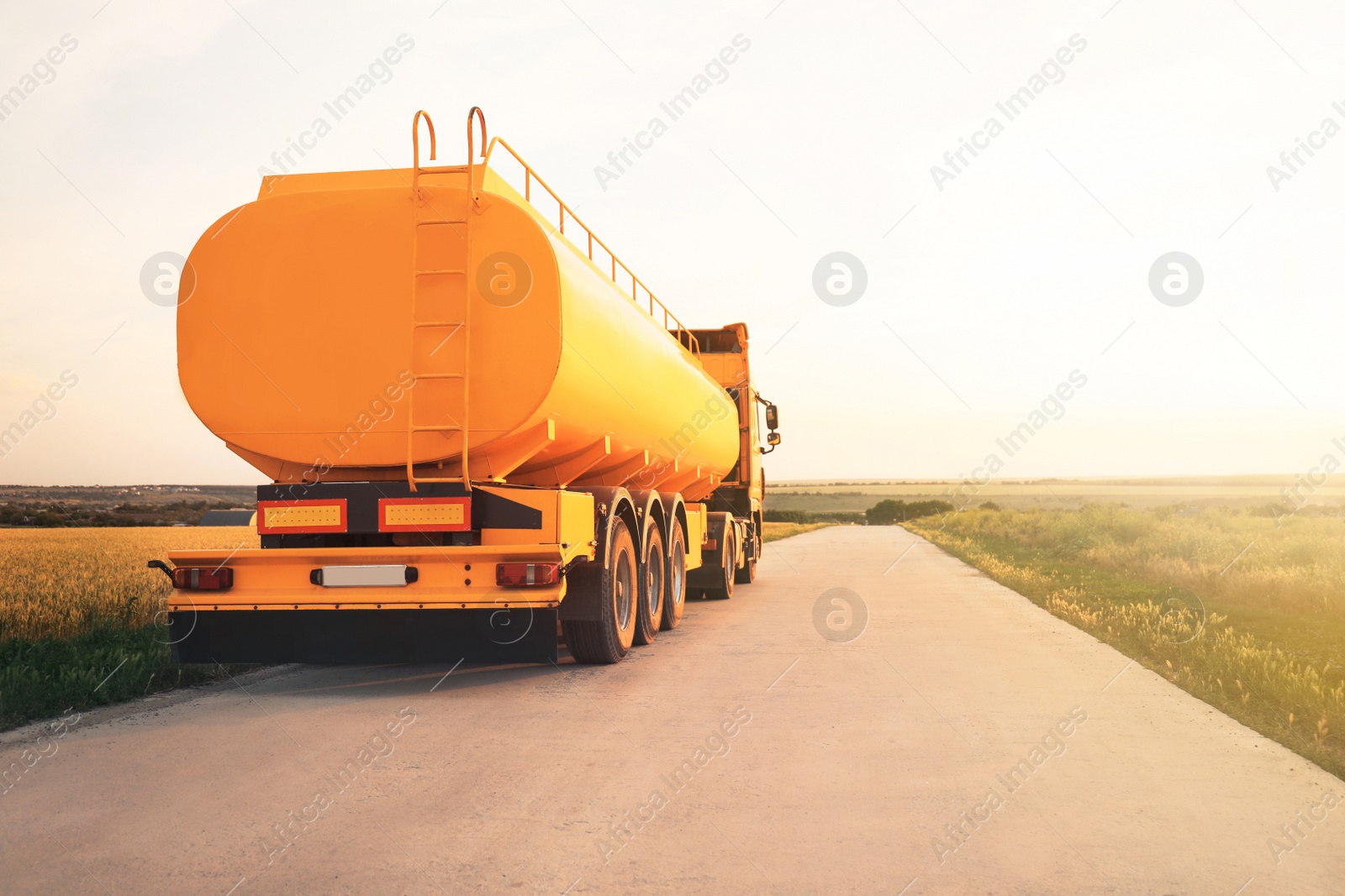 Photo of Modern yellow truck on country road. Space for text