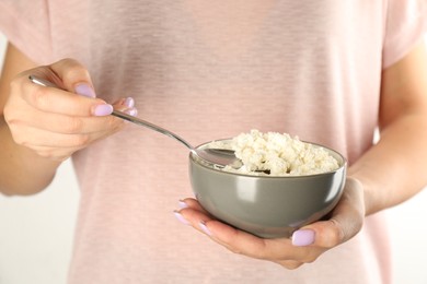 Photo of Woman with delicious fresh cottage cheese on white background, closeup