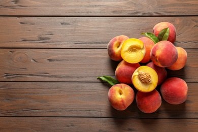 Fresh sweet peaches on wooden table, top view