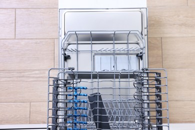 Open clean empty dishwasher in kitchen, top view