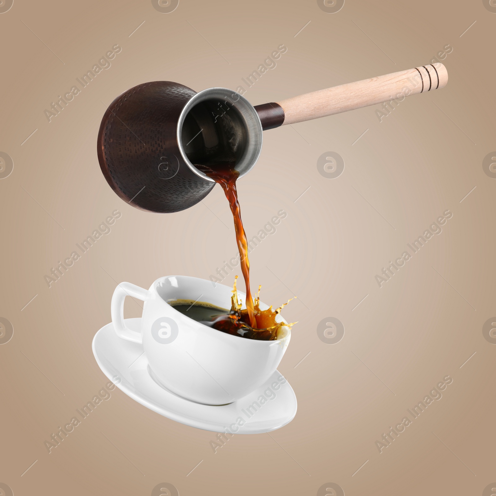 Image of Pouring freshly brewed aromatic coffee from turkish pot into cup. Objects in air on dark beige background