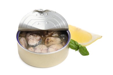 Open tin can with mackerel chunks, lemon and basil on white background